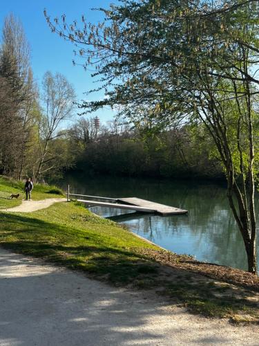une personne se promenant le long d'un sentier à côté d'un lac dans l'établissement Studio La Marne Paris, à Saint-Maur-des-Fossés