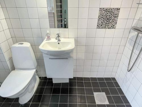 a white bathroom with a toilet and a sink at 4 star holiday home in HÖRBY in Hörby