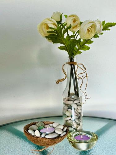 a vase with a bouquet of roses and a bowl of eggs at Alise in Bar