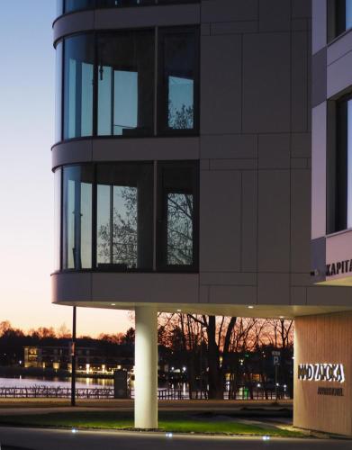 オルシュティンにあるApartament Premium nad jeziorem, przy samej plaży miejskiejの夕日を背景に高層建築