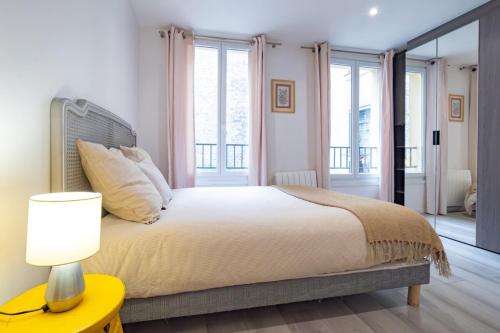 une chambre avec un grand lit et une lampe dans l'établissement Appartement 4 Guests aux Invalides, à Paris
