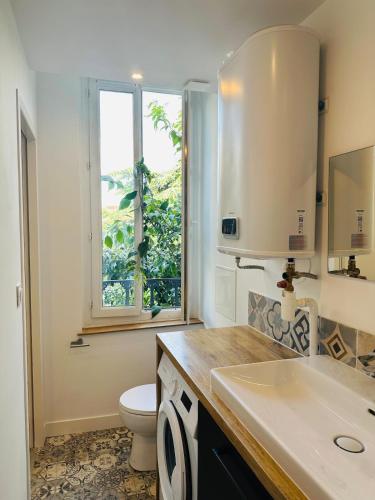 une salle de bain avec toilettes, lavabo et fenêtre dans l'établissement #YellowCenter #20m Jardin Public, à Cognac