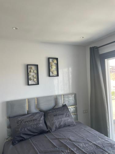a bed in a bedroom with three pictures on the wall at Casas Del Mar Cabo N in Martil
