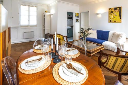 une salle à manger et un salon avec une table et des chaises dans l'établissement Appartement Haussmannien Étoile, à Paris