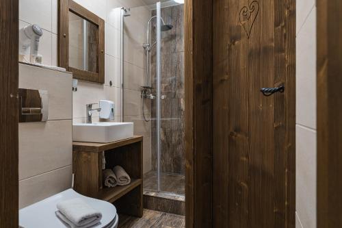 a bathroom with a shower and a toilet and a sink at SPA & WELLNESS Penzión Zorhill in Ždiar