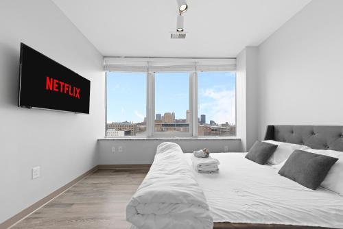 a white room with a bed and a large window at Luxe Condo in Downtown Cleveland l 2 TV's l Parking in Cleveland