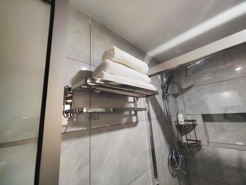 a bathroom with a shower with towels on a shelf at Zen Haven Lavington in Nairobi