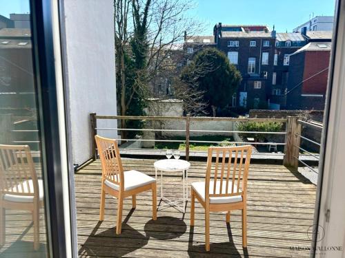 three chairs and a table on a balcony at Le Botanique des Augustins -100m2 en plein centre in Liège
