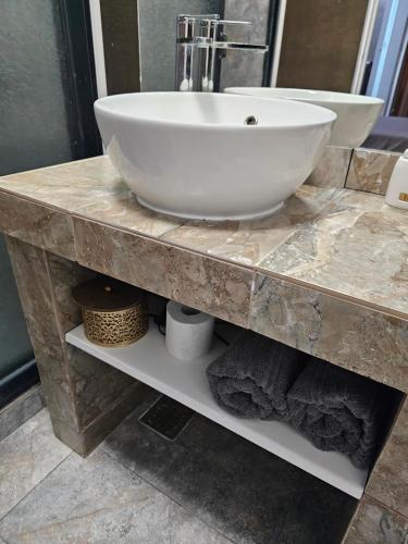 a white sink on a marble counter in a bathroom at Grand Bahia Relaxury in Costinesti