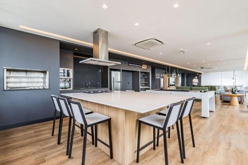 a kitchen with a large island with chairs around it at GO Carlos Gomes by My Way in Porto Alegre