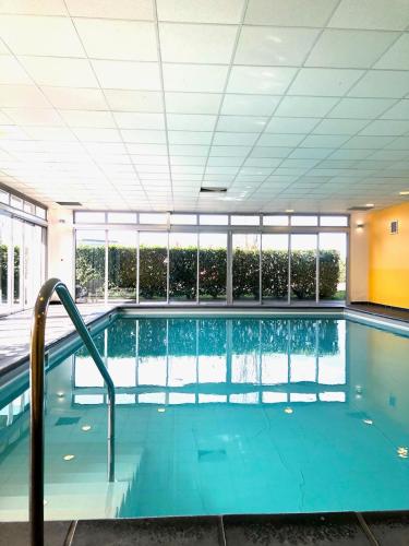 une grande piscine dans un immeuble dans l'établissement Le Fitness & Business Studio - Airbus -Piscine Spa, à Toulouse