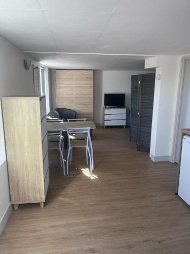 une pièce vide avec une table et des chaises dans l'établissement l’ Amont, à Étretat