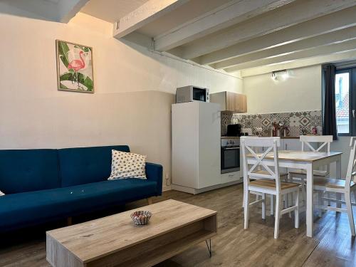 un salon avec un canapé bleu et une table dans l'établissement Le Toit - 2 chambres - 4 personnes - Netflix - Calme, à Nancy