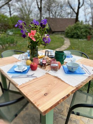 a wooden table with a vase of flowers on it at Le Dolmen, charme sport et détente in Saint-Chels