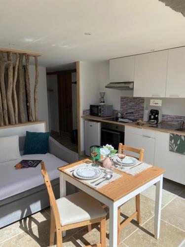 a living room with a table and a kitchen at Le Dolmen, charme sport et détente in Saint-Chels