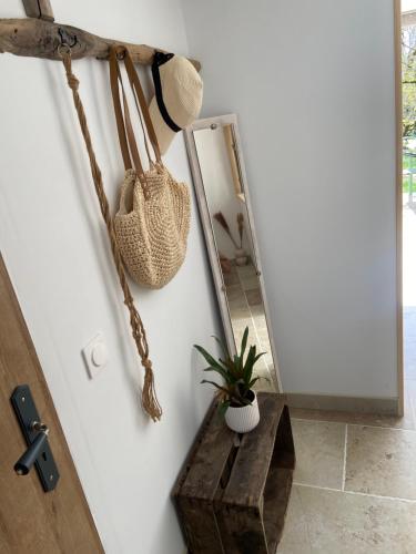 a hallway with a mirror and a bench and a purse at Le Dolmen, charme sport et détente in Saint-Chels