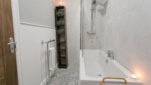 a bathroom with a shower and a bath tub at Beau Townhouse in Beaumaris