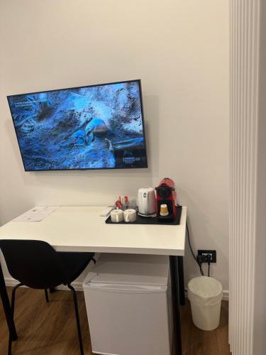 a white desk with a computer monitor on a wall at Sweet Rooms in La Spezia
