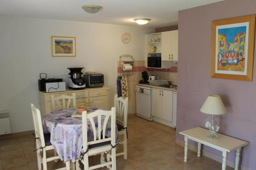 une cuisine et une salle à manger avec une table et des chaises dans l'établissement villa soleil au bord du canal du midi, à Homps