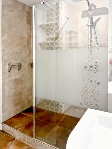 La salle de bains est pourvue d'une cabine de douche en verre. dans l'établissement App 94 m2, balcon, ascenseur, 2 ch, 4 couchages, à Aurillac