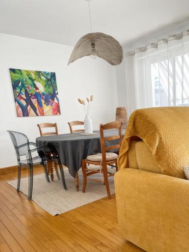 une salle à manger avec une table, des chaises et un canapé dans l'établissement App 94 m2, balcon, ascenseur, 2 ch, 4 couchages, à Aurillac