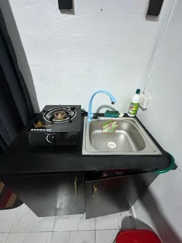 莱基Private Fully Serviced Studio Apartment At Ilasan lekki ikate, AC, Toilet is Shared, Netflix,WiFi,prime,private kitchen的厨房柜台设有水槽和炉灶。