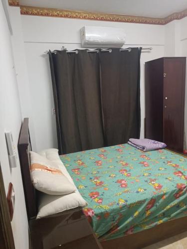 a bedroom with a bed with a green comforter at Blue lagoon resort in Ras Sedr