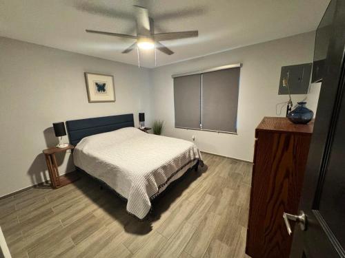 a bedroom with a bed and a ceiling fan at A charming villa with a spectacular pergola and patio in Edinburg