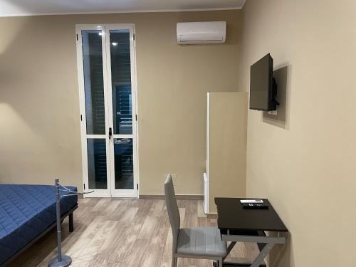 a room with a bed and a table and a television at Exclusive B&B in Reggio Calabria