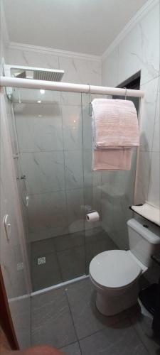 a bathroom with a shower with a toilet and a glass door at Casa Container em Monte Verde - 800m do Centro in Monte Verde