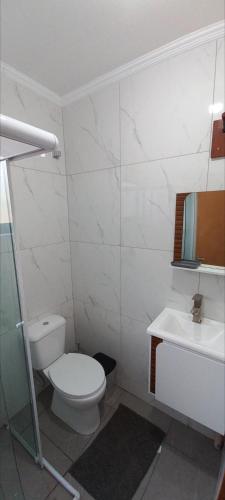 a white bathroom with a toilet and a sink at Casa Container em Monte Verde - 800m do Centro in Monte Verde