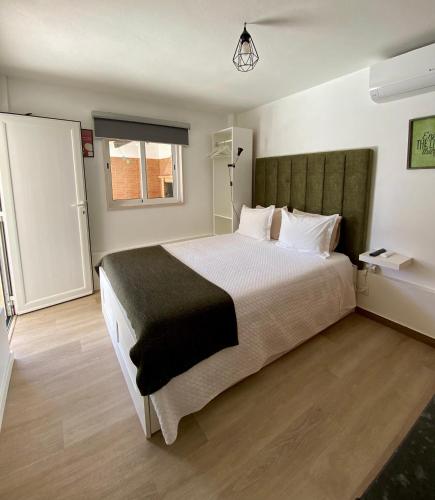 a bedroom with a large bed and a window at Little Place Nazaré in Nazaré