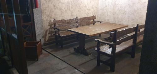 a wooden table and two benches next to a wooden table and benches at DALLAR Guest House in Yerevan