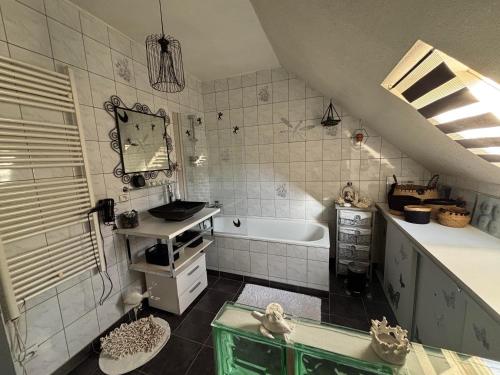 une salle de bain avec un lavabo et une baignoire dans l'établissement Chez Cath, à Leysse