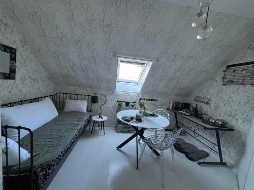 une chambre avec un lit et une table dedans dans l'établissement Chez Cath, à Leysse