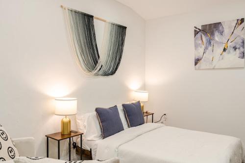 a white bedroom with a bed and a couch at Miami North Beach in North Miami Beach
