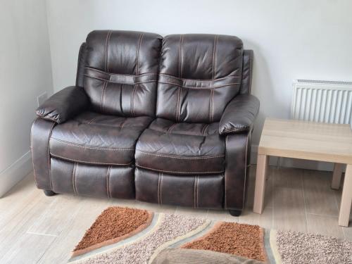 a brown leather chair in a room with a table at Farm View Lodge in Kilkenny