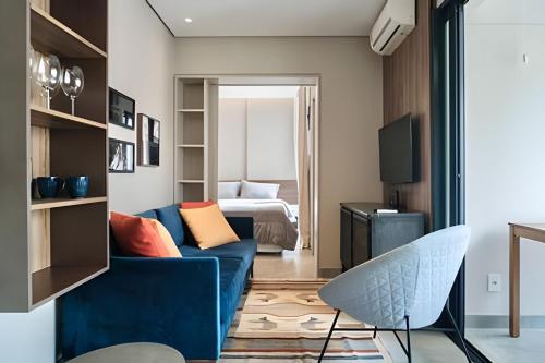 a living room with a blue couch and a bed at Occa Stay Cobogó - A115 in Sao Paulo