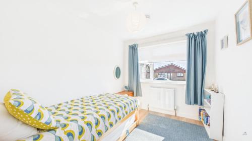 a bedroom with a bed and a window at Sea Breeze in Brading