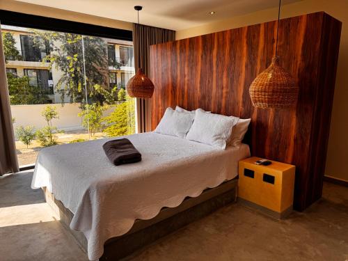 une chambre avec un grand lit avec un mur en bois dans l'établissement Nook Tulum Luxury Condohotel by Marea, à Tulum