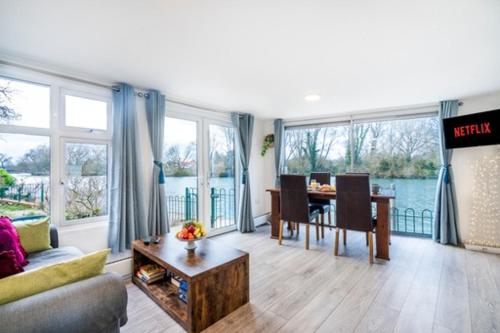 a living room with a couch and a table at RIVER RETREAT- near Holloway U, Thorpe Park and Heathrow airport in Thorpe