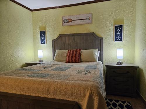 a bedroom with a large bed with two night stands at Roatan Seaside Rentals in West Bay