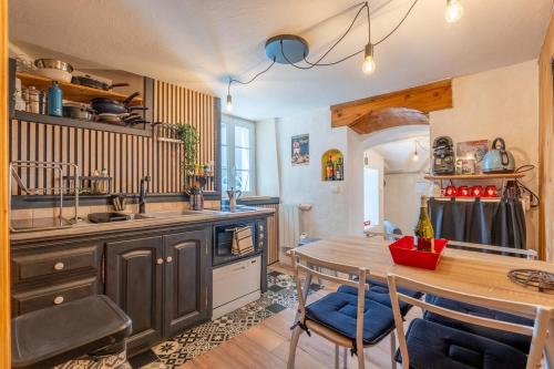 a kitchen with a wooden table and a dining room at Nid Cosy - Appartement Atypique in Flumet