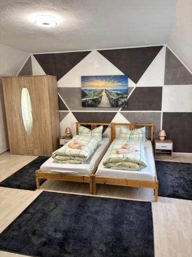 a bedroom with two beds and a checkered wall at Andrei Ferienwohnung in Marktbreit