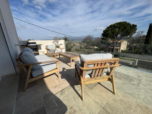 a patio with two chairs and a table on a balcony at Les Restanques in Trets