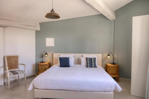 Un dormitorio con una cama blanca con almohadas azules. en Le Hameau Fleur de Pierres , Chambre , Gite et Table d'Hôtes, en Murs