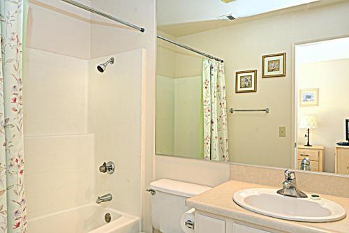 a bathroom with a sink and a toilet and a shower at Biarritz Mirage - 1BR Downtown Condo in Palm Springs