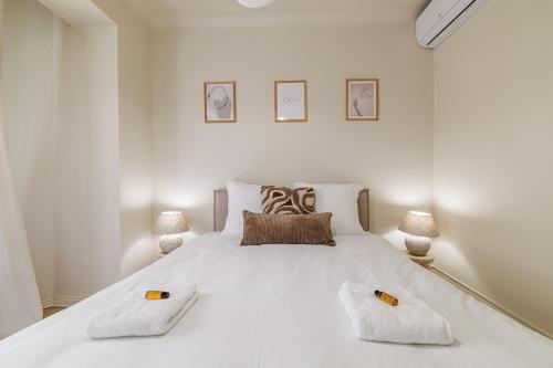 - une chambre blanche avec un grand lit blanc et 2 oreillers dans l'établissement Cannes banana apartment, à Cannes