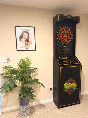a pinball machine and a palm tree in a room at Lakefront A-frame Hot Tub, Dock, Kayaks, Games in Lake Ariel