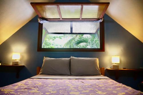 a bedroom with a window with a bed and two lamps at Franky's Fare in Fare